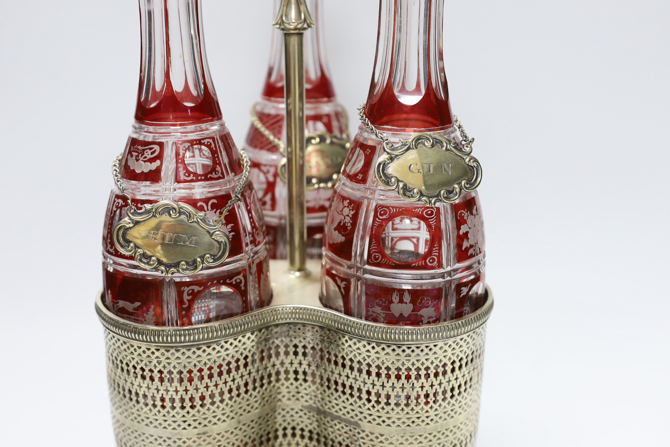 A Victorian three bottle ruby flashed glass and electroplate decanter stand, overall 46cms high